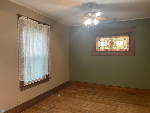 unfurnished room with hardwood / wood-style floors, a healthy amount of sunlight, and crown molding