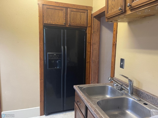 kitchen with black fridge with ice dispenser and sink