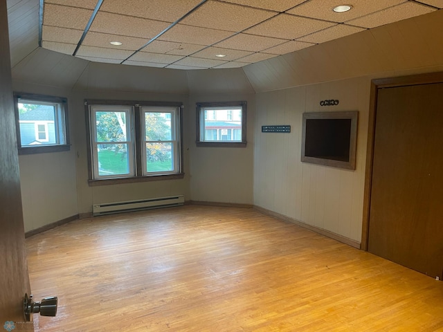 unfurnished room with a paneled ceiling, light hardwood / wood-style flooring, and a baseboard radiator