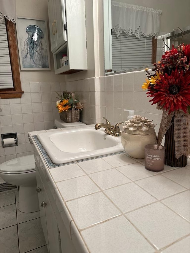 bathroom with tile patterned flooring, vanity, toilet, and tile walls