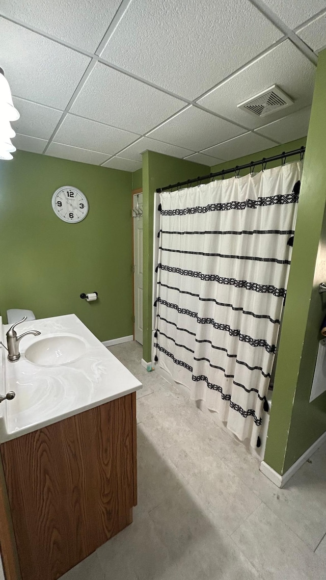 bathroom with a paneled ceiling and vanity