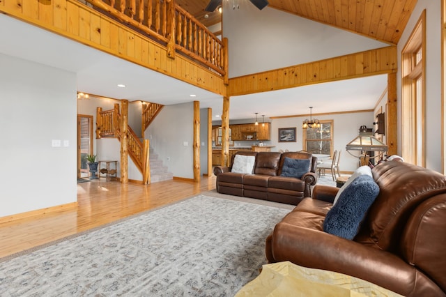 living room featuring wooden ceiling, high vaulted ceiling, ceiling fan with notable chandelier, crown molding, and hardwood / wood-style flooring