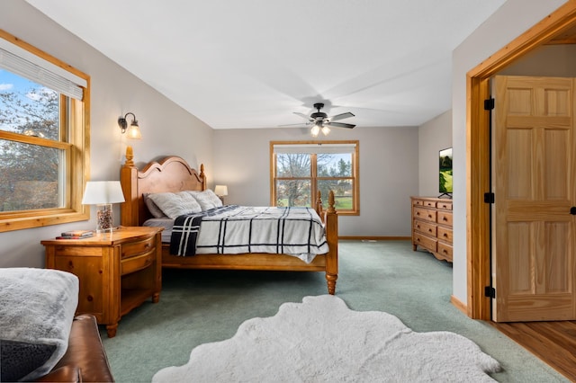 bedroom with ceiling fan, light carpet, and multiple windows