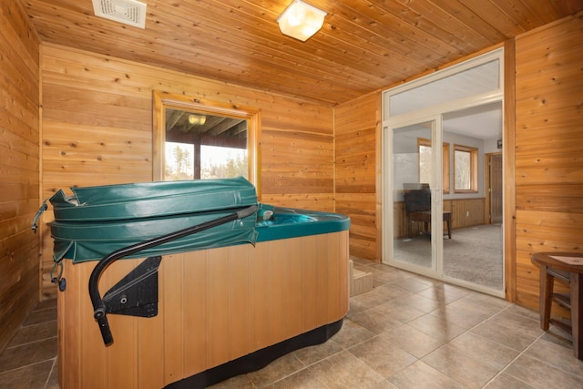 miscellaneous room featuring tile patterned flooring, a hot tub, wooden ceiling, and wood walls