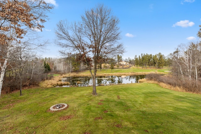 view of yard with a water view and an outdoor fire pit