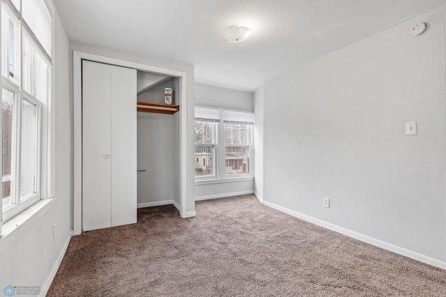 unfurnished bedroom featuring carpet, a closet, and multiple windows