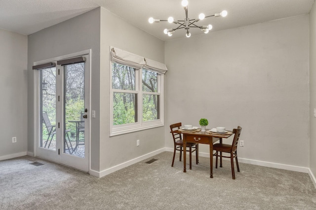 dining area with light colored carpet and a chandelier