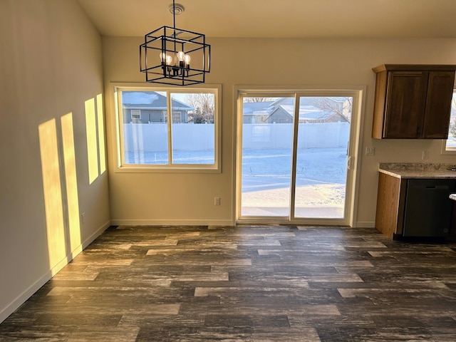 unfurnished dining area featuring a chandelier, plenty of natural light, and dark wood-type flooring