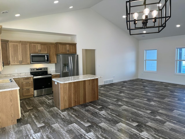 kitchen featuring pendant lighting, a center island, an inviting chandelier, dark hardwood / wood-style floors, and appliances with stainless steel finishes