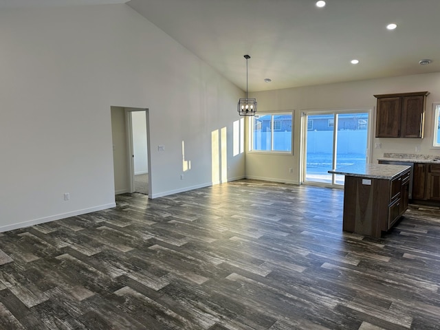 kitchen featuring dark hardwood / wood-style flooring, high vaulted ceiling, a chandelier, decorative light fixtures, and dark brown cabinets