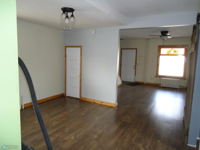 spare room featuring radiator, ceiling fan, and dark hardwood / wood-style flooring