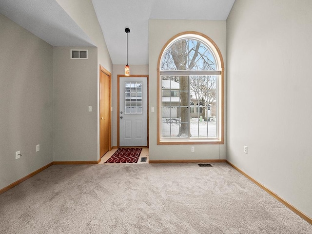 carpeted entryway featuring lofted ceiling