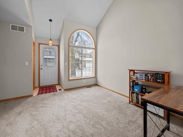 carpeted entrance foyer featuring lofted ceiling