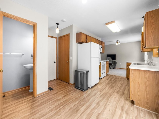 kitchen featuring sink, white appliances, and light hardwood / wood-style flooring