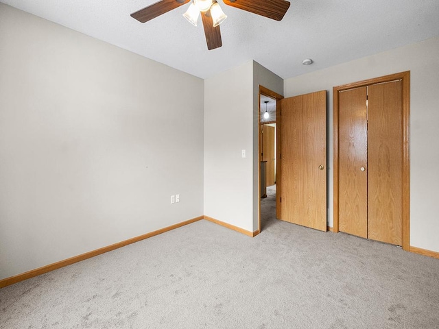 unfurnished bedroom featuring light carpet and ceiling fan