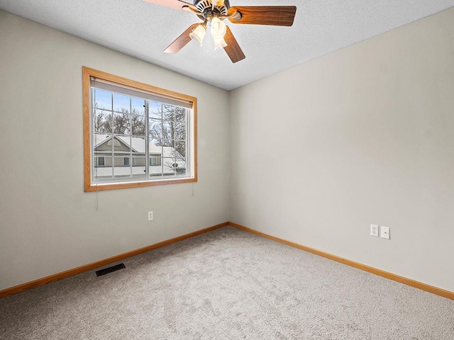 carpeted spare room featuring ceiling fan