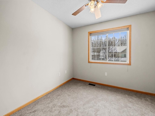 carpeted empty room featuring a textured ceiling and ceiling fan