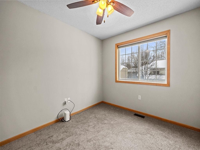 spare room featuring a textured ceiling, carpet flooring, and ceiling fan