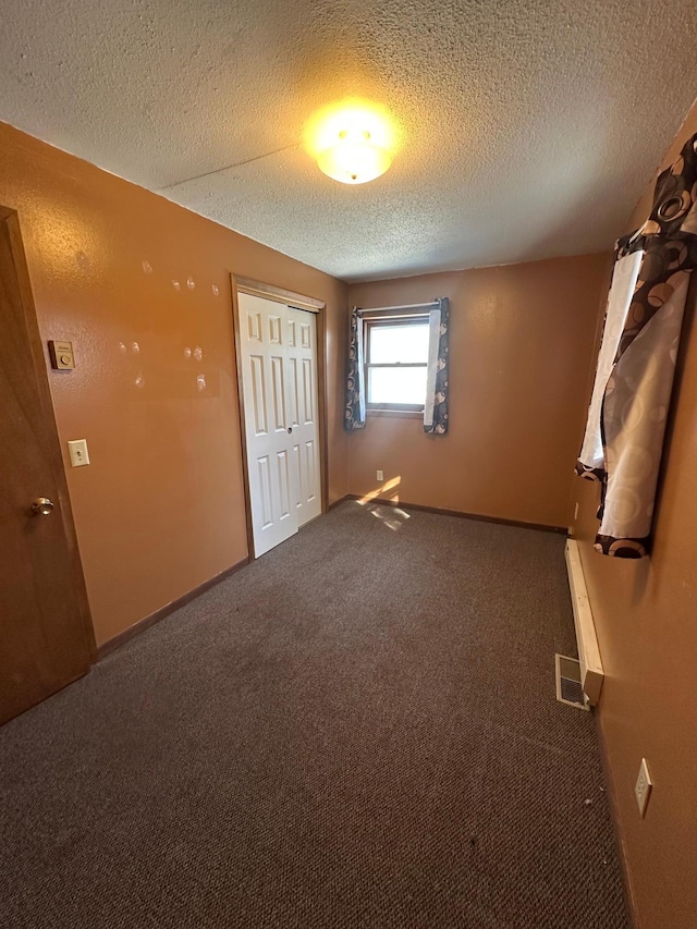 spare room featuring visible vents, baseboards, carpet, and a textured ceiling