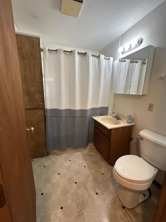 bathroom with tile patterned floors, toilet, a textured ceiling, a shower with shower curtain, and vanity