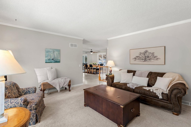 living room featuring a textured ceiling, ceiling fan, ornamental molding, and light carpet