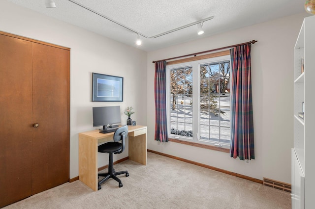 office with a textured ceiling, light colored carpet, and rail lighting