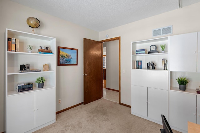 carpeted home office with a textured ceiling