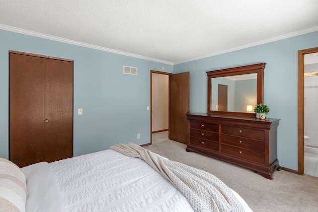 bedroom with ornamental molding, a closet, light carpet, and connected bathroom