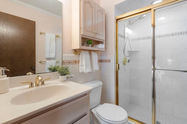 bathroom with tile walls, toilet, ornamental molding, and a shower with shower door