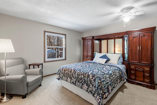 carpeted bedroom featuring ceiling fan and a textured ceiling