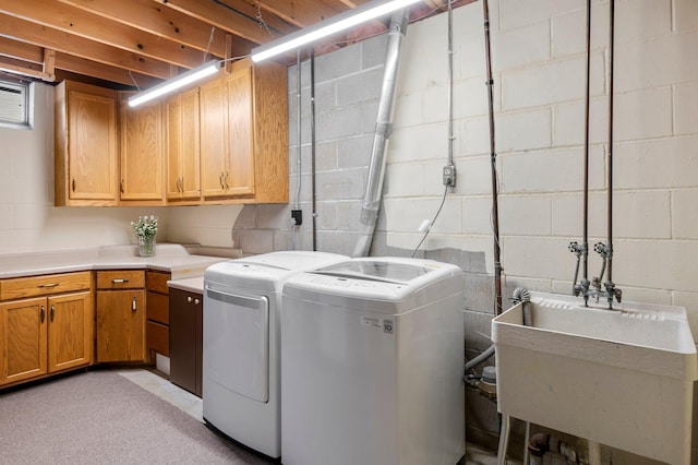 laundry area with washer and dryer, cabinets, and sink