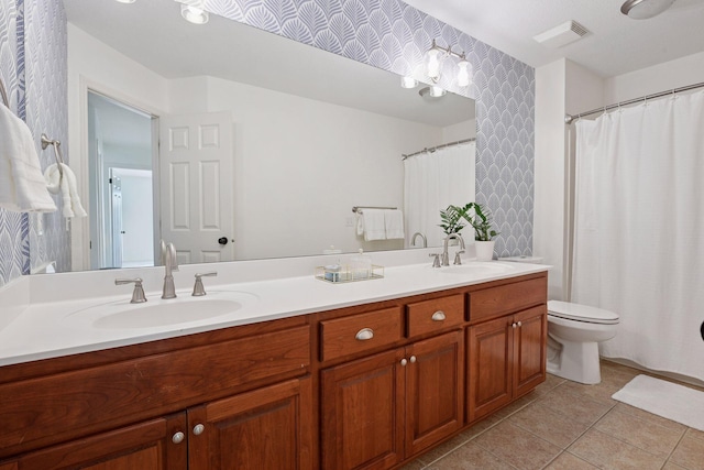 bathroom featuring tile patterned floors, double vanity, visible vents, and a sink