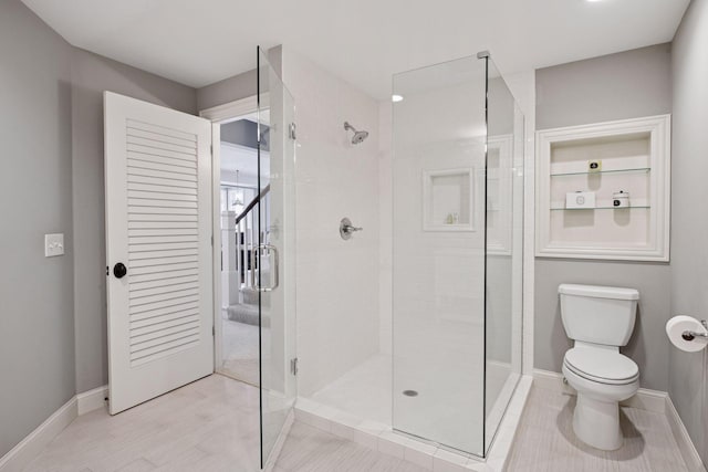 full bathroom featuring baseboards, toilet, and a shower stall