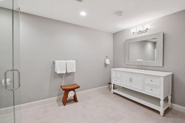 bathroom featuring vanity, recessed lighting, baseboards, and a shower with door