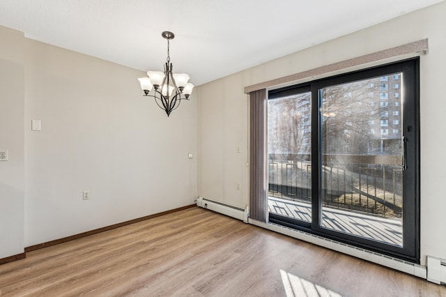 empty room with light wood-type flooring, baseboard heating, and a notable chandelier