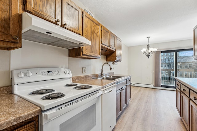 kitchen featuring sink, hanging light fixtures, baseboard heating, a notable chandelier, and white appliances