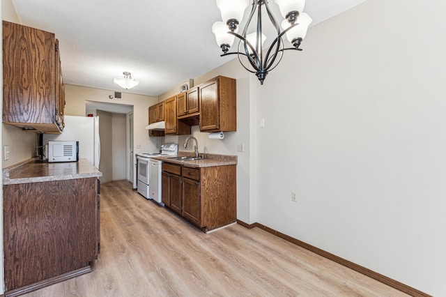 kitchen with sink, hanging light fixtures, white range with electric stovetop, light hardwood / wood-style floors, and a chandelier