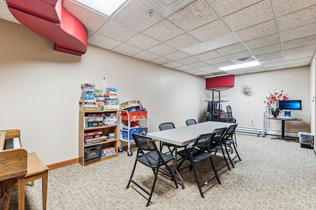 dining space with carpet flooring and a paneled ceiling