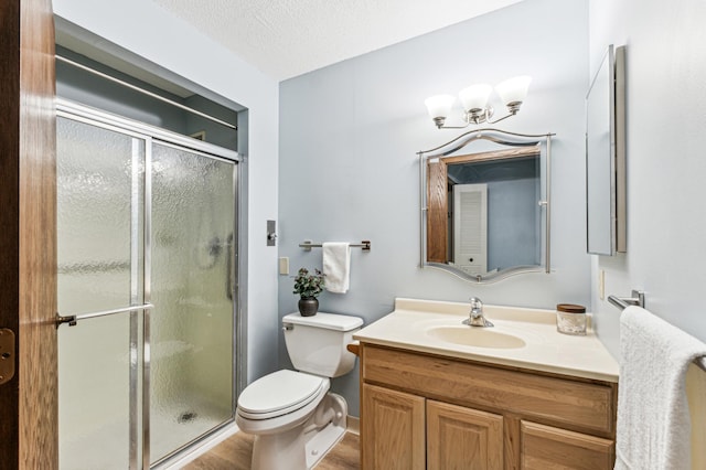 bathroom featuring walk in shower, vanity, a textured ceiling, wood-type flooring, and toilet