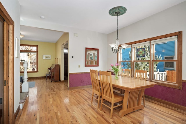 dining space with a chandelier and light wood-type flooring