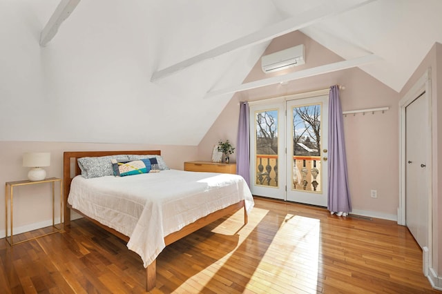 bedroom with lofted ceiling with beams, access to outside, hardwood / wood-style floors, and a wall unit AC