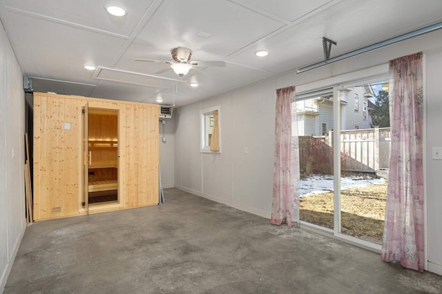 empty room featuring concrete flooring, a wall unit AC, and ceiling fan