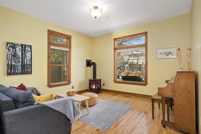 living area with a wood stove and light hardwood / wood-style flooring