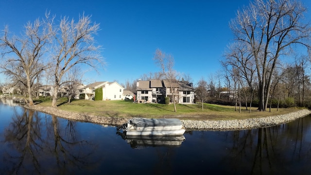 rear view of house with a yard and a water view