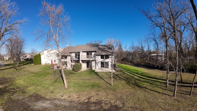 back of property with a lawn, a balcony, and a patio