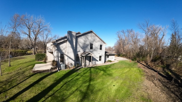 back of property featuring a patio and a lawn