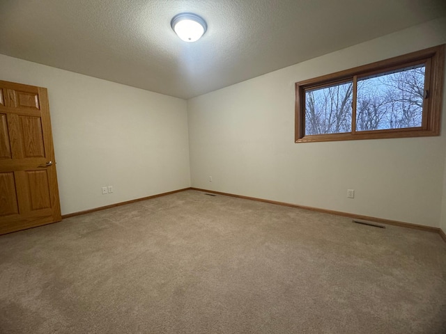 carpeted empty room with a textured ceiling