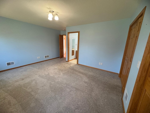 unfurnished bedroom featuring light carpet and a textured ceiling