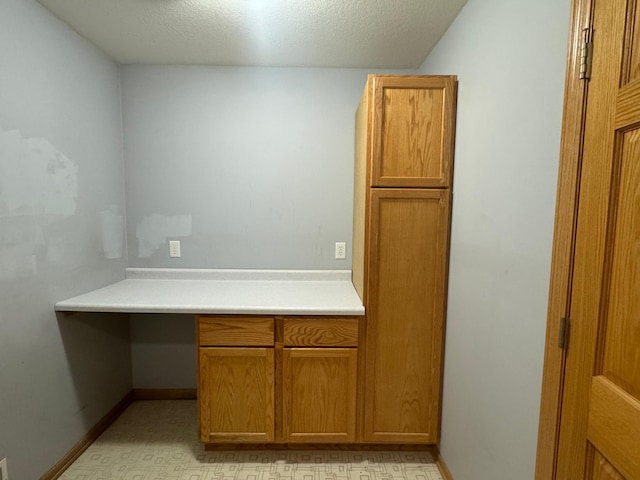 unfurnished office with built in desk and a textured ceiling