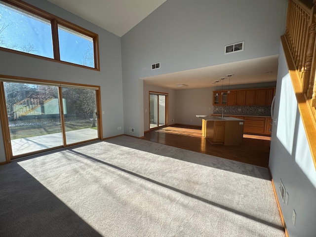 unfurnished living room featuring dark wood-type flooring and high vaulted ceiling